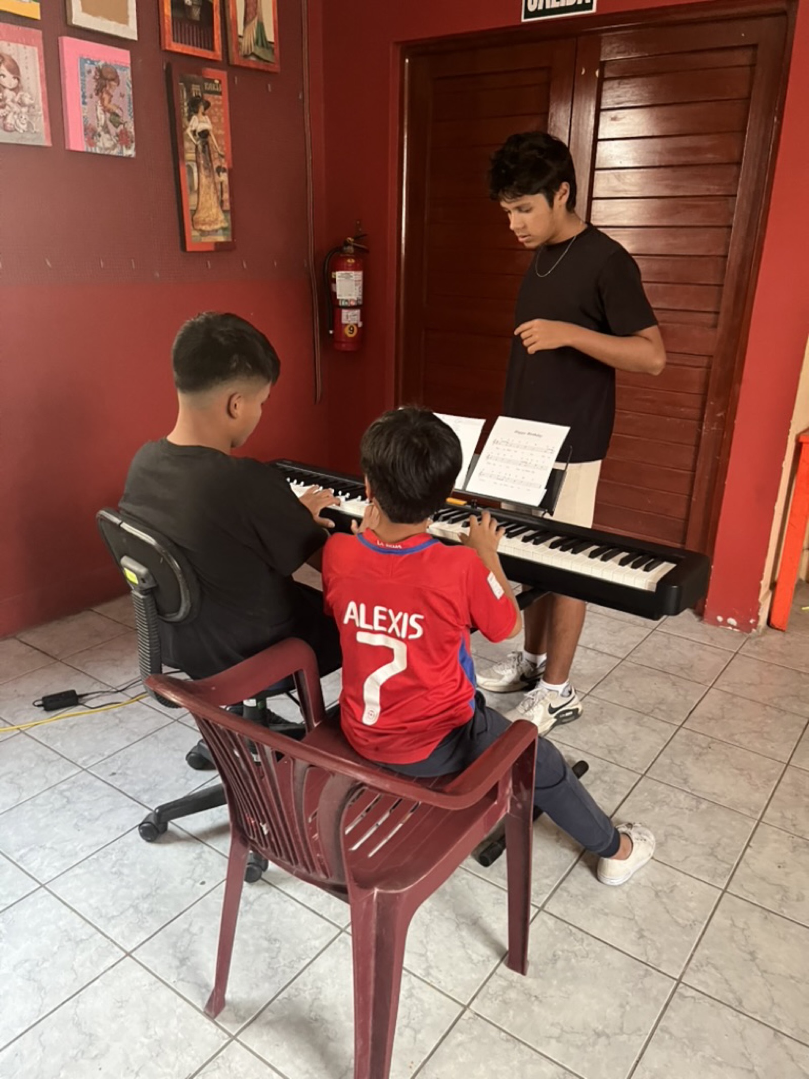 Students practicing on the donated keyboard during an early lesson in Trujillo